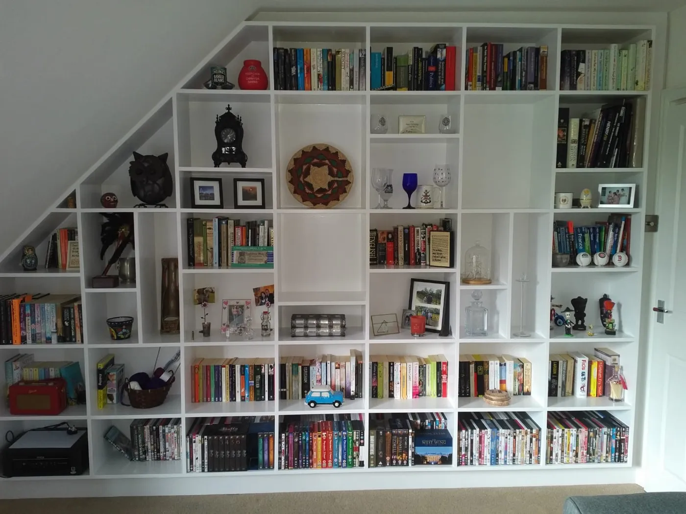 Floor-to-ceiling fitted library shelving built under a sloped loft ceiling